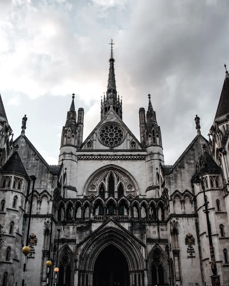 The Royal Courts of Justice in London: a gothic stone facade under a heavy sky.